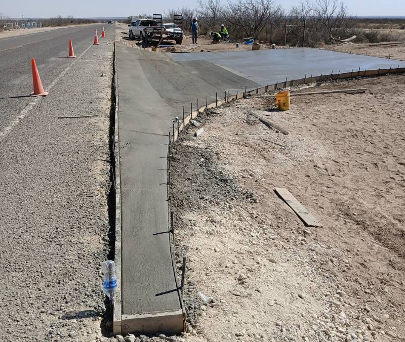 Permian Paving crew pouring a fresh concrete apron and entryway along a roadside in Big Spring TX.